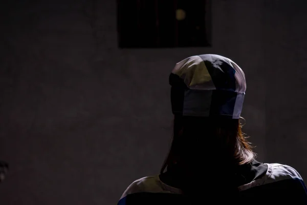 Female prisoner standing with her back in a jail cell — Stock Photo, Image