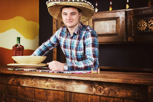 Smiling male bartender in a sombrero leaned on bar counter in Me — Stock Photo, Image