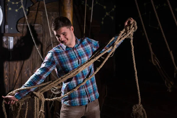 Young guy freed from captivity and selecting from ropes — Stock Photo, Image