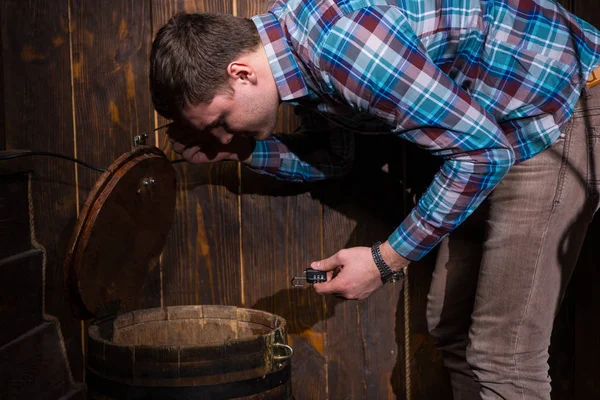 Young man opened a barrel and trying to solve a conundrum to get — Stock Photo, Image