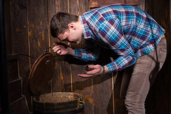 Young male opened a barrel and trying to solve a conundrum to ge — Stock Photo, Image