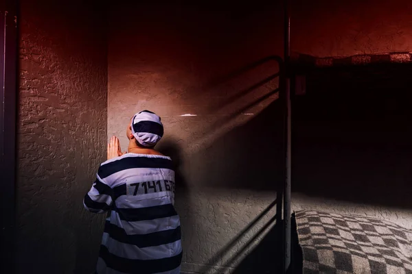 Hombre prisionero está sentado en la esquina y rezando en una prisión c — Foto de Stock