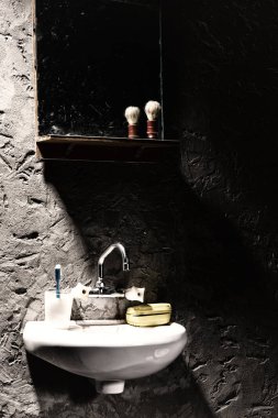 Bir diş fırçası ve altında bir sabun kutusu için bir kupa ile lavabo