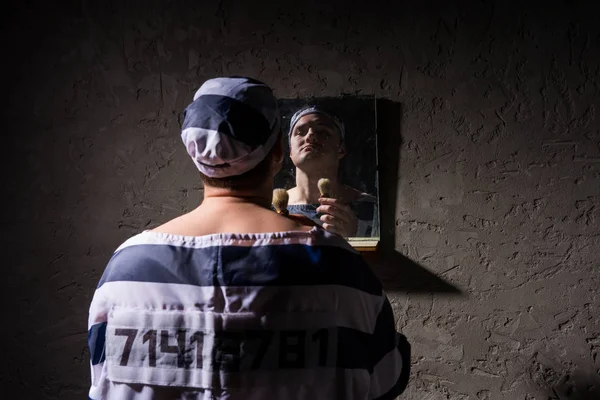 Prisoner standing with shave brush and looking at his reflection — Stock Photo, Image