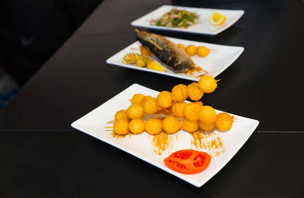 Delicious fried cheese and fish on white plates — Stock Photo, Image