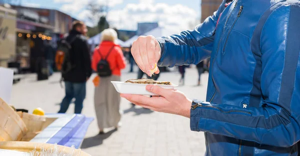 Manliga händer hålla en enda färska öppnade ostron och tränger ut — Stockfoto