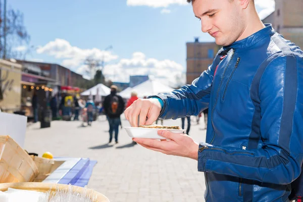 Ung vacker man hålla en enda färska öppnade ostron och sque — Stockfoto