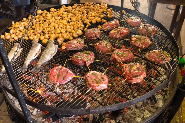 Аппетитные маринованные стейки и грибы на горячем гриле — стоковое фото