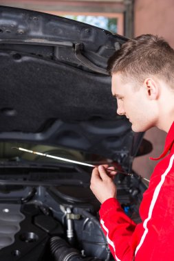 Genç erkek motor mekanik bir arabada yağ seviye kontrol