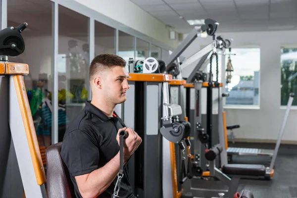 Joven trabajando y haciendo ejercicios en el gimnasio — Foto de Stock