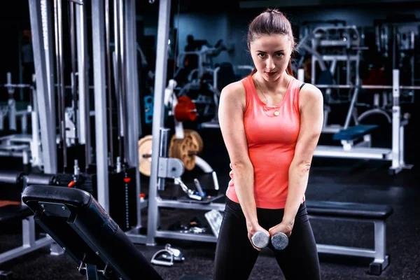 Joven mujer deportiva en ropa deportiva levantando algunos pesos — Foto de Stock