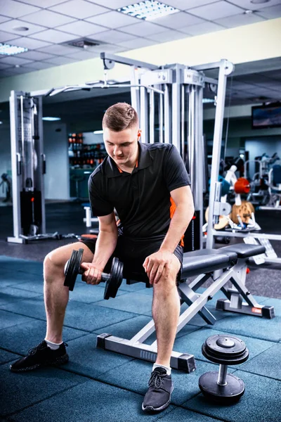 Young sportive man in sportswear lifting some weights — Stock Photo, Image