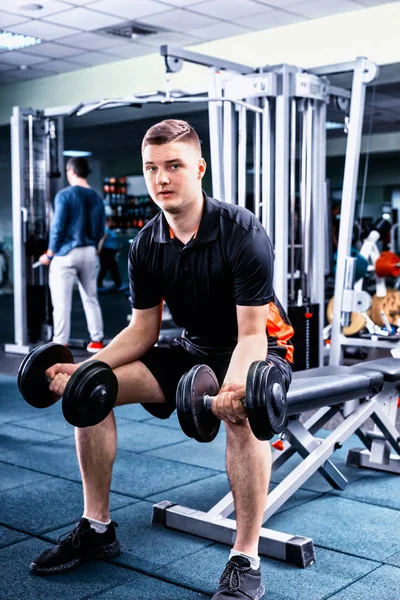 Beau jeune homme sportif en vêtements de sport soulevant quelques poids — Photo