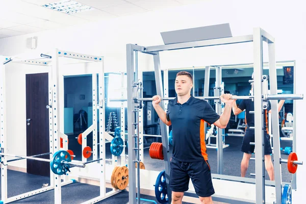 Fit young man in sportswear lifting barbells — Stock Photo, Image