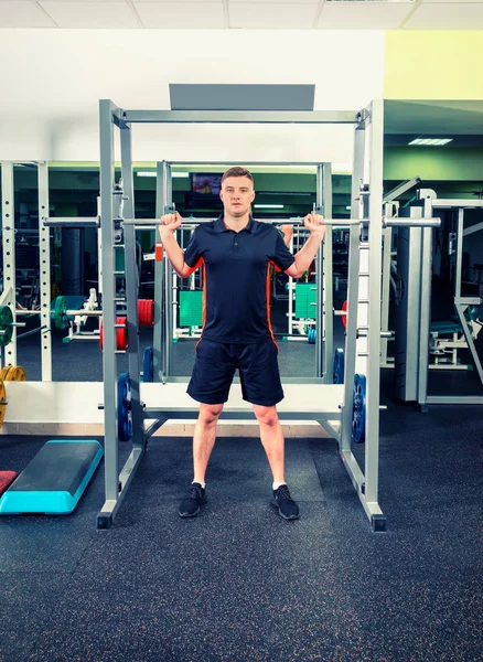 Schöner Mann in Sportkleidung, der Hanteln hebt — Stockfoto