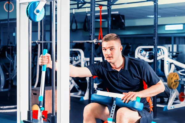 Atlético joven en ropa deportiva haciendo ejercicio en un baño de la máquina — Foto de Stock