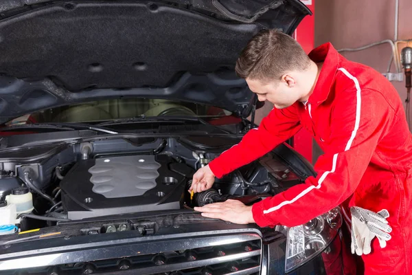 Mécanicien automobile masculin va vérifier le niveau d'huile dans une voiture — Photo