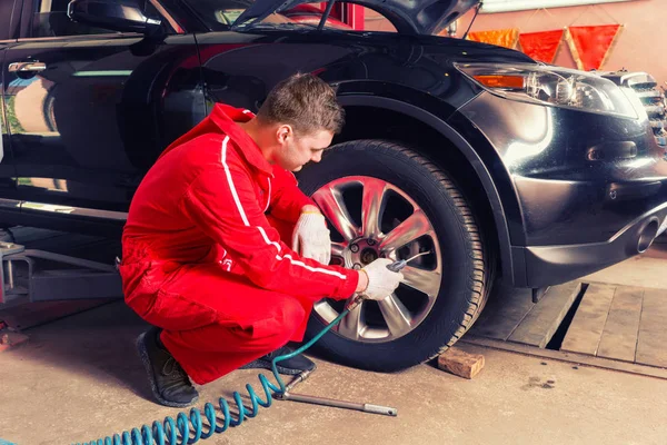 Young motor mechanic is going to check the air pressure — Stock Photo, Image