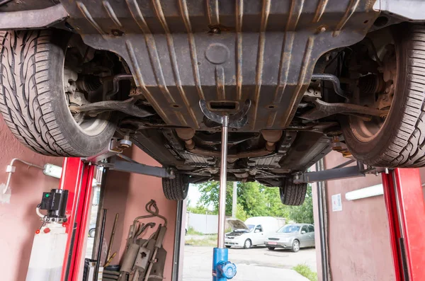 Car on a lift in a auto service station — Stock Photo, Image