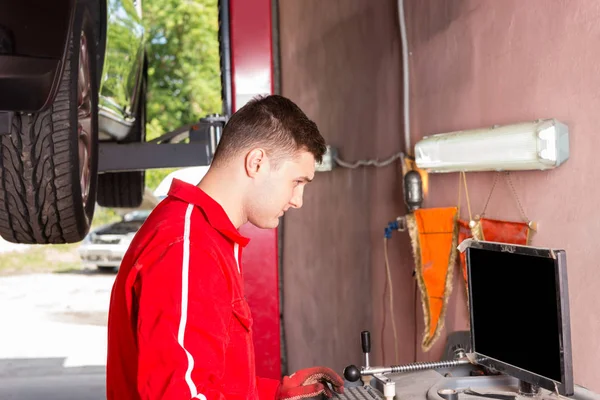 Young male mechanic checking the readout — Stock Photo, Image
