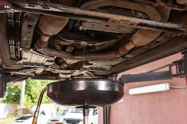 Jato de óleo flui para fora em equipamentos para mudar o óleo do motor — Fotografia de Stock