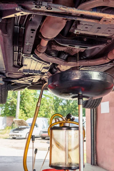 Jato de óleo flui para fora em equipamentos para mudar o óleo do motor em um gar — Fotografia de Stock