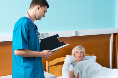 Boynundaki phonendoscope üniformalı genç doktor bakar 