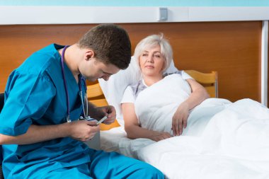 Onun boyun seyir üzerinde phonendoscope ile üniformalı yakışıklı doktor