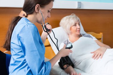 Çekici kadın hemşire üniforması ile phonendoscope measuri olduğunu