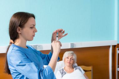 Üniformalı kadın doktor iğne için yapmak hazırlanıyor 