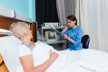 Üniformalı kadın doktor electrocardiogra analizini tutuyor