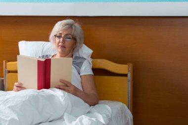 Bayan hasta olsa da hastanede yatan bir kitap okuyor