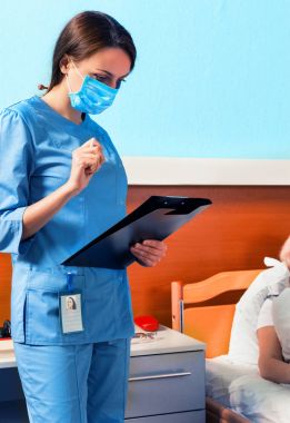 Klibi de arıyorsunuz bir maske takarak üniformalı genç çekici hemşire