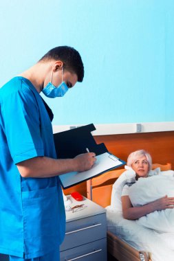 Bazı notlar repo içinde yapım bir maske takarak üniformalı genç doktor