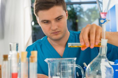 S çalışmayı üniformalı genç konsantre bilim adamı portresi