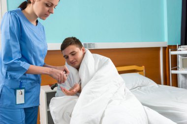 Çekici hemşire hasta hasta wheelcha üzerinde oturup hapları vermeye