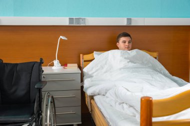 Yorgan içinde erkek hasta hasta hastane yatağında yalan kaplı