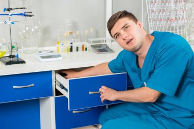 Yakışıklı genç asistan bir durumda bir şey arıyor