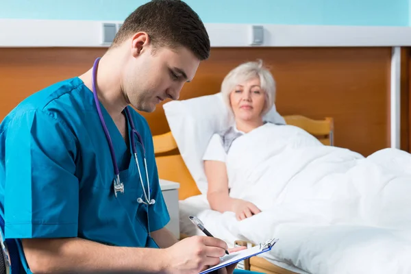 Guapo joven doctor en uniforme con fonendoscopio en su —  Fotos de Stock