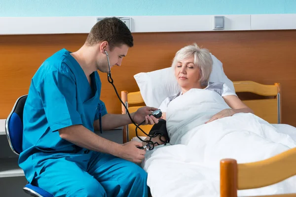 Boynundaki phonendoscope üniformalı genç erkek doktor metredir