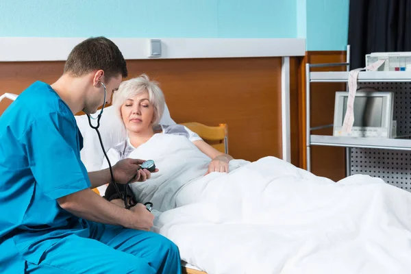 Homme médecin en uniforme avec phonendoscope sur le cou est Measuri — Photo