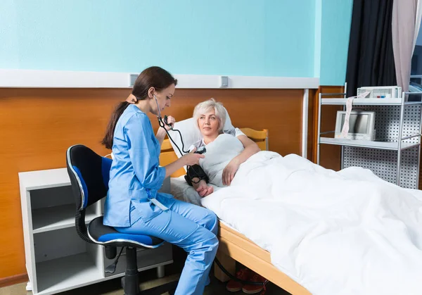 Phonendoscope ile üniformalı genç kadın doktor t ölçme