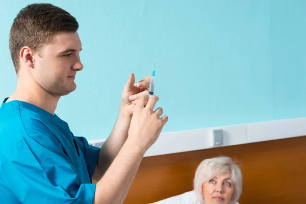 Giovane medico maschio in uniforme si prepara a fare un'iniezione — Foto Stock