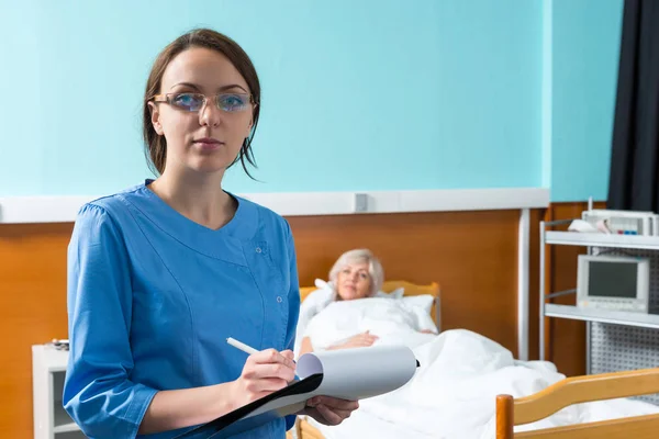 Kvinnlig sjuksköterska eller läkare i uniform bär en mask och glasögon mak — Stockfoto