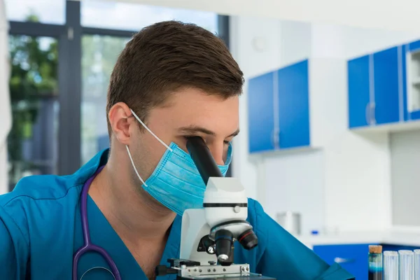 Wissenschaftler oder Arzt in Uniform mit Phonendoskop auf dem Kopf — Stockfoto