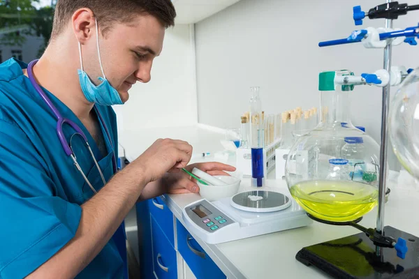 Tek tip bir maske takarak içinde genç erkek bilim adamı toz ağırlığında 