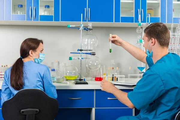 Vue arrière de jeunes scientifiques masculins et féminins en uniforme — Photo