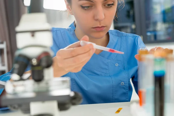 Young concentrated female scientist in uniform working on some r — Stock Photo, Image