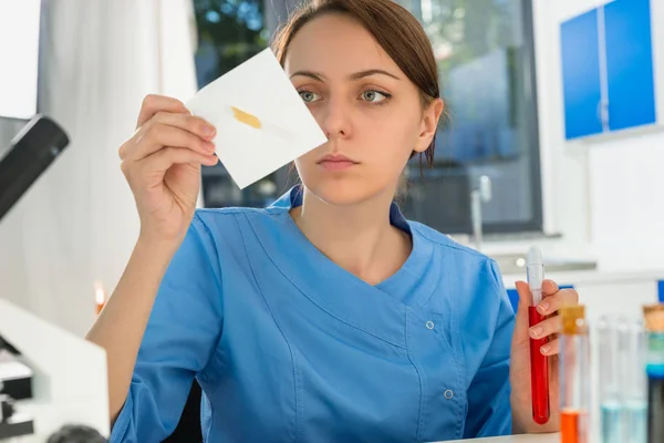 Konzentrierte Wissenschaftlerin in Uniform, die an einer Forschungsarbeit arbeitet — Stockfoto