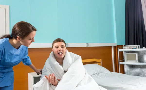 Beautiful nurse giving pills to ill patient sitting on wheelchai — Stock Photo, Image